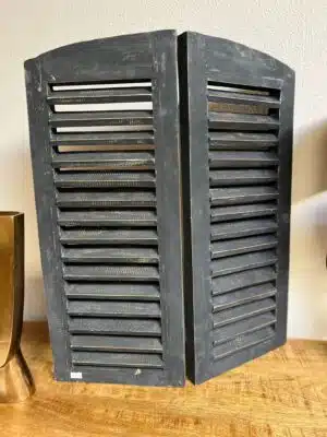 Vergrijsde dubbele houten louvre luiken met scharnier.
