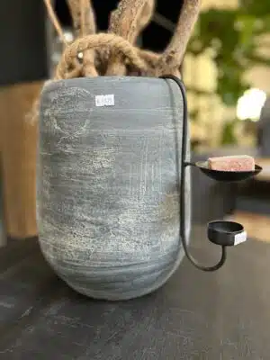 Vergrijsde stenen pot met takken en licht snoer